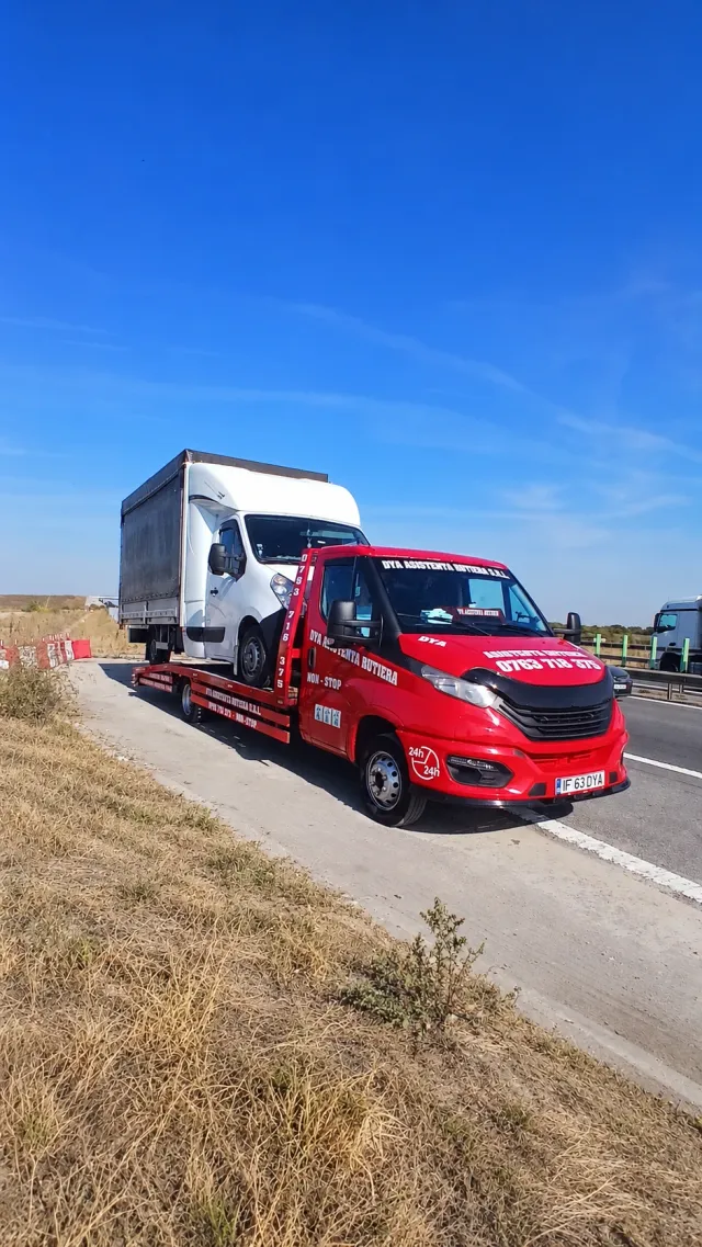 Platformă auto roșie cu o dubă încărcată