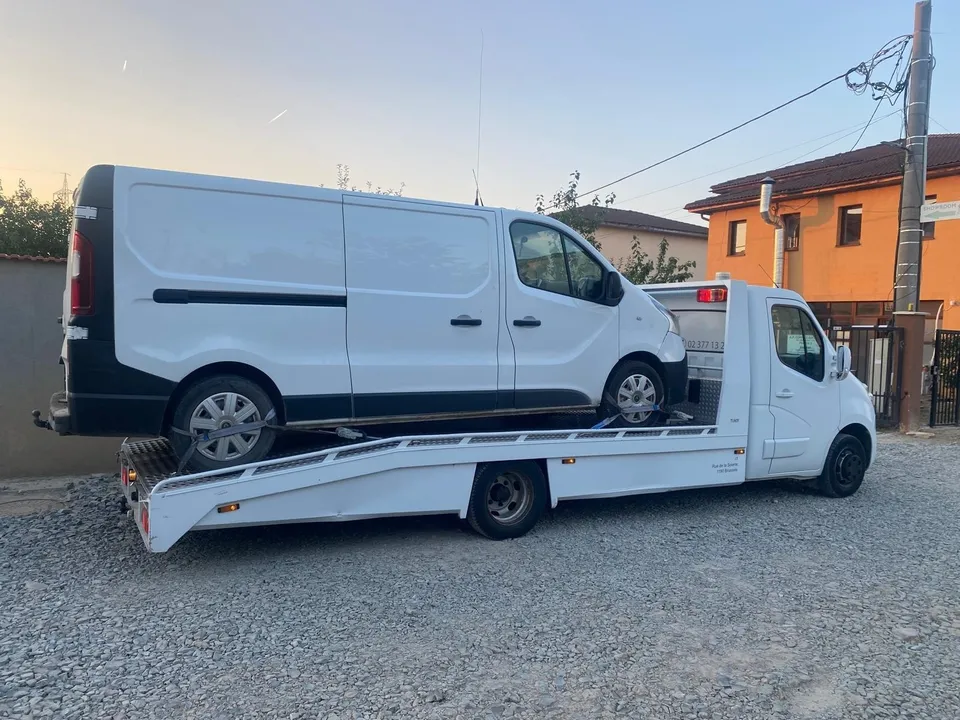 Platformă auto albă cu o dubă albă încărcată